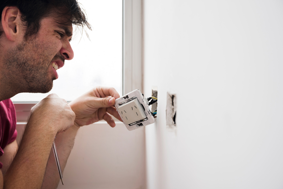 a man fixing an electical issue at house